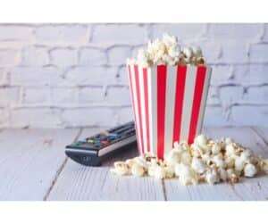 Popcorn in container and TV remote on Table