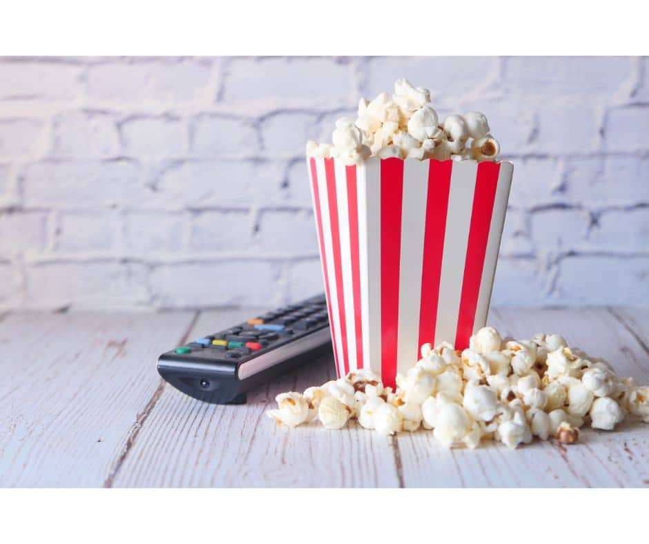 Popcorn in container and TV remote on Table